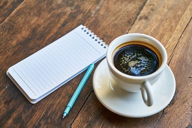 kopje koffie, blocnote, pen